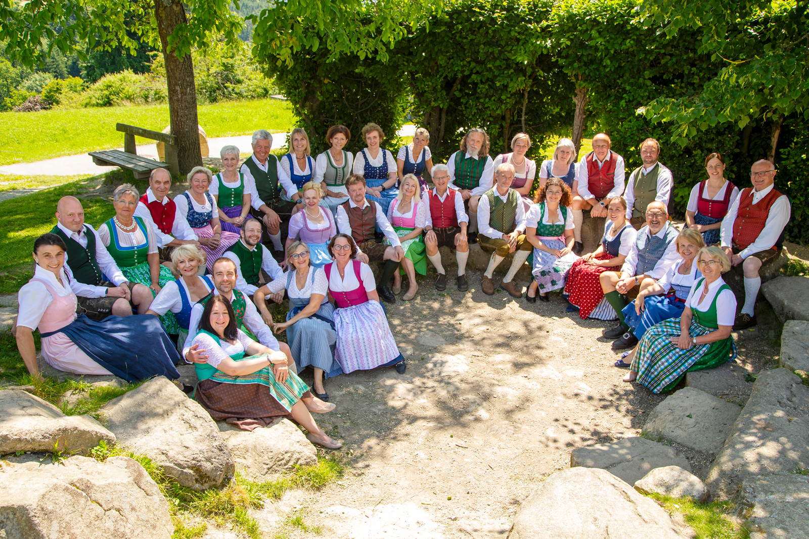 Bachlchor in Sommertracht sitzend im Freien unter einem Baum